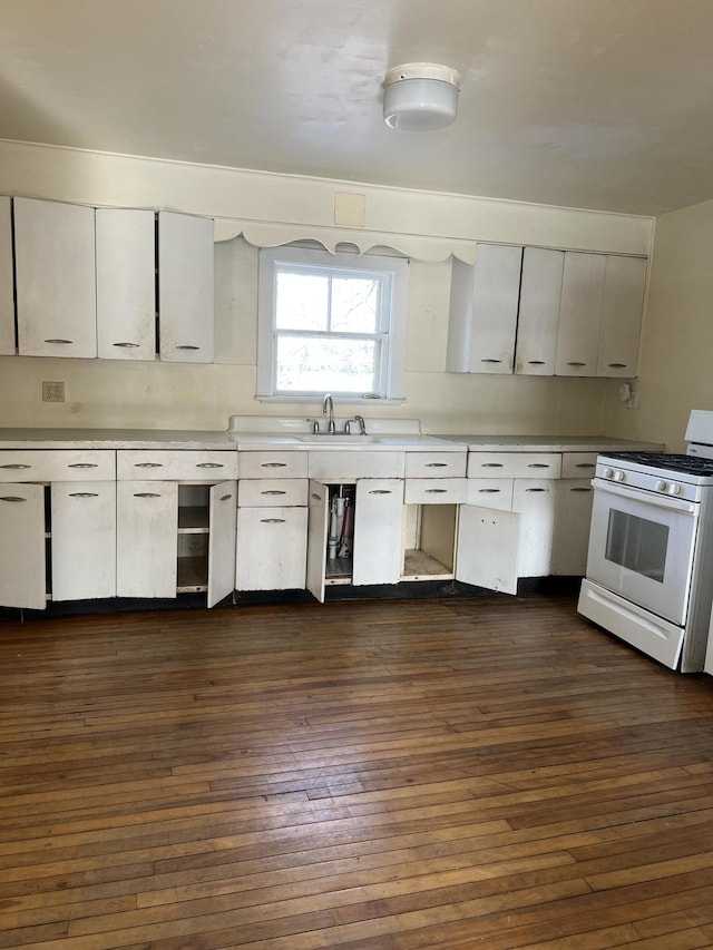 kitchen featuring dark wood-type flooring, white gas range, sink, and white cabinets