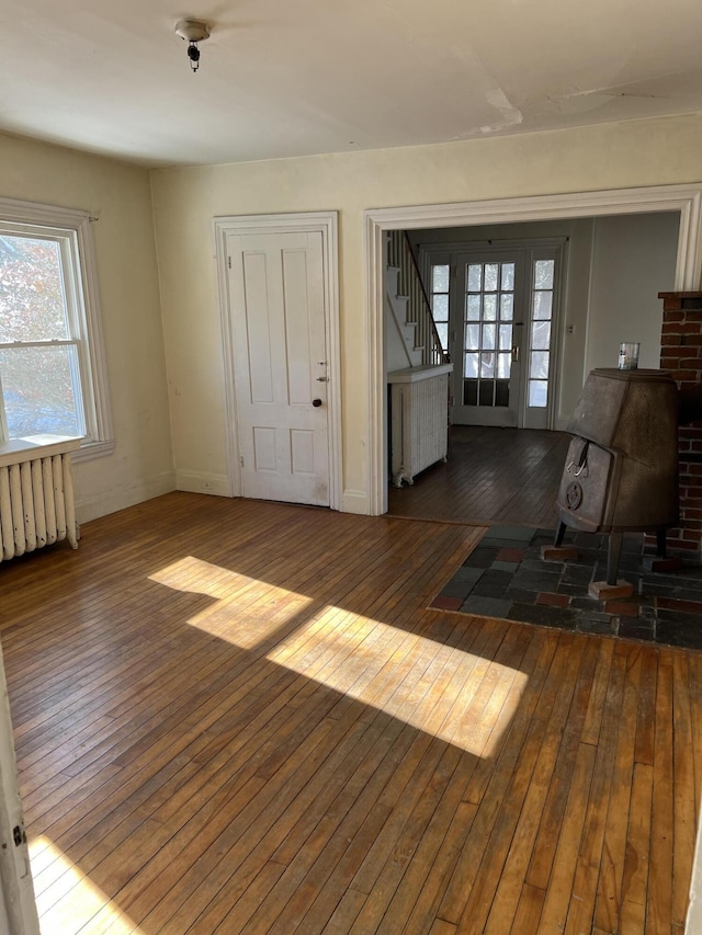 foyer with dark wood-type flooring and radiator heating unit