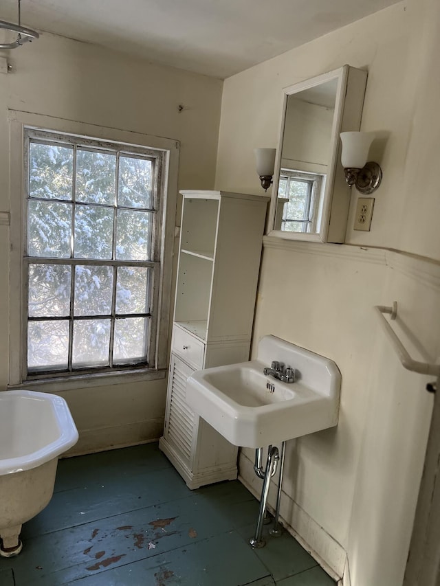 bathroom featuring sink and a tub to relax in