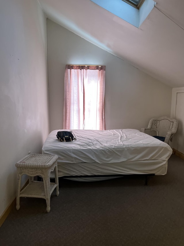 bedroom with lofted ceiling with skylight and carpet flooring