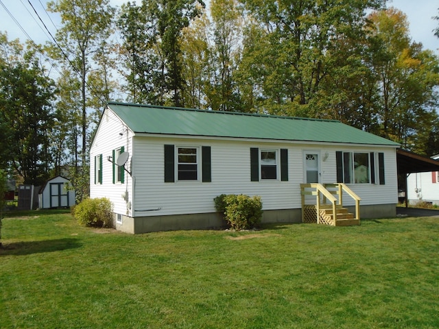 view of front of home with a front yard and a storage unit