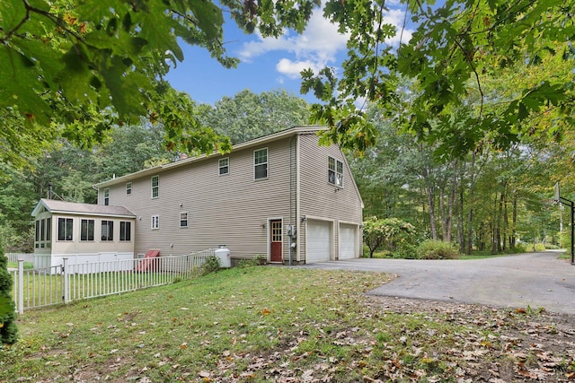 rear view of house featuring a garage and a lawn