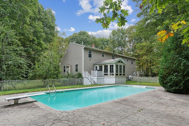 view of pool featuring a diving board, a sunroom, and a patio