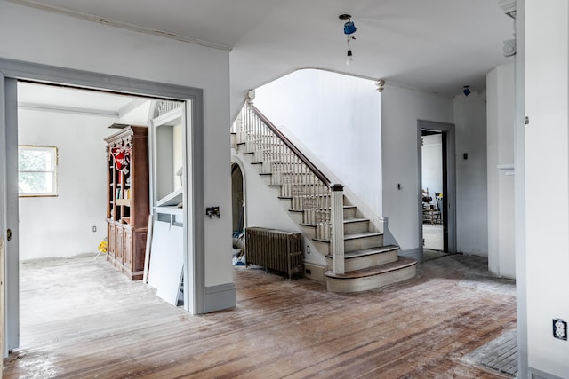 stairway with ornamental molding and hardwood / wood-style flooring