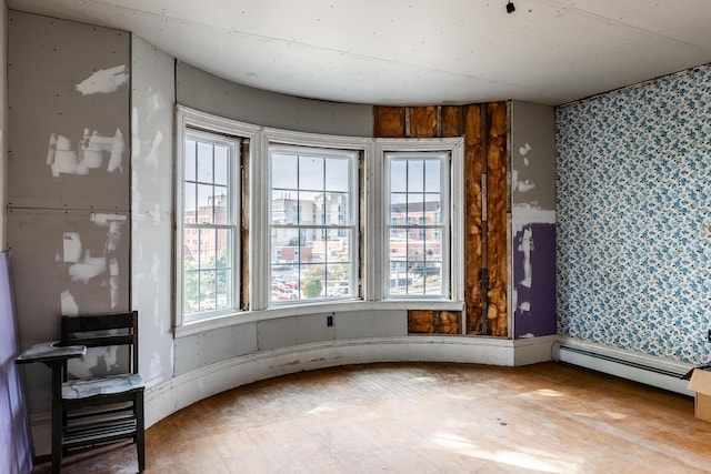 spare room featuring a baseboard radiator and wallpapered walls