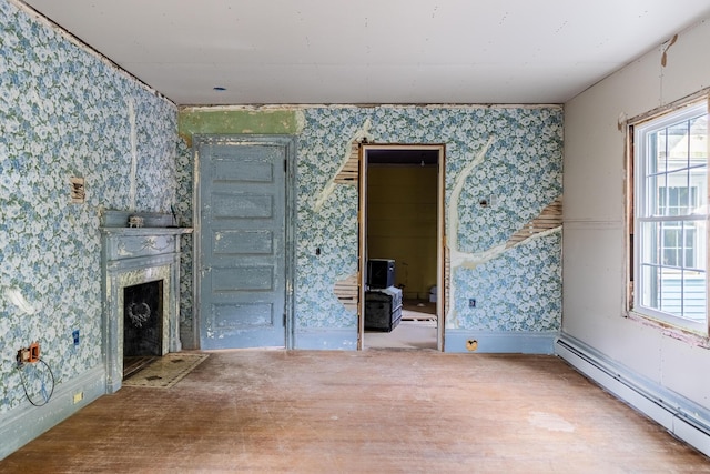 unfurnished living room featuring plenty of natural light, a fireplace, a baseboard heating unit, and wallpapered walls