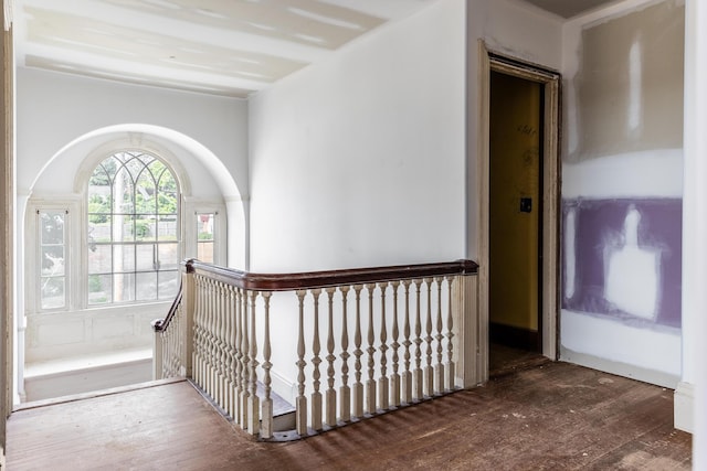 hallway with wood-type flooring and an upstairs landing