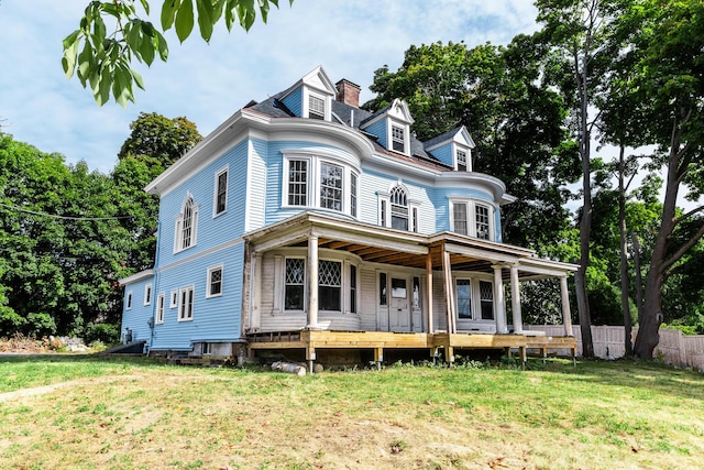 victorian house with a porch and a front yard