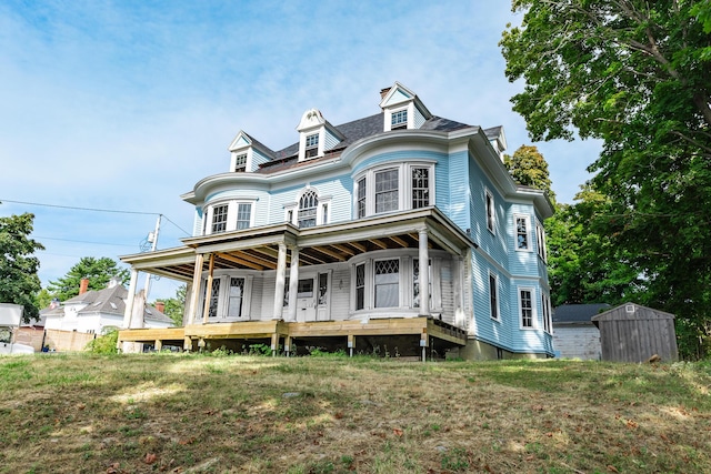 view of front of property featuring a front lawn, an outdoor structure, and a storage unit
