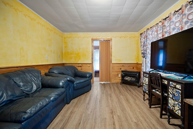 living room with wood walls, light hardwood / wood-style floors, a fireplace, and a healthy amount of sunlight