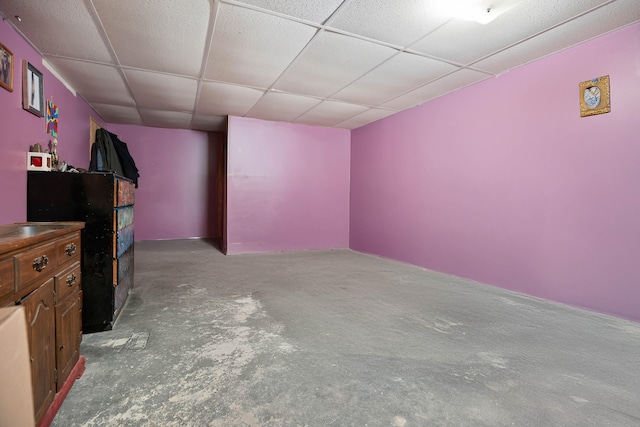 unfurnished living room featuring concrete flooring and a paneled ceiling