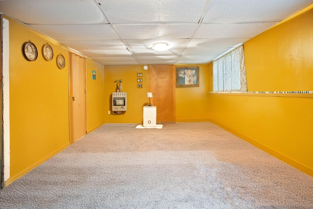 basement featuring heating unit, a drop ceiling, and carpet