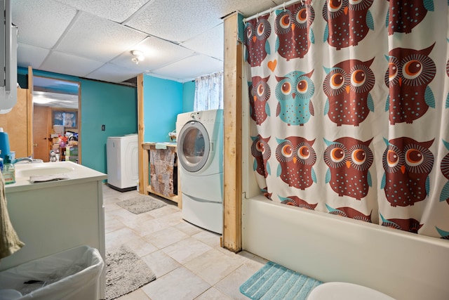 washroom with washer / dryer, light tile patterned floors, and sink