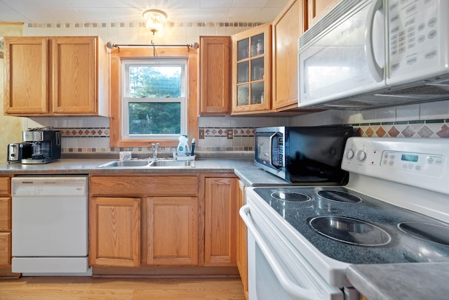 kitchen with light hardwood / wood-style flooring, sink, white appliances, and tasteful backsplash