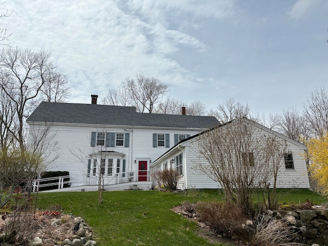 rear view of property featuring a yard