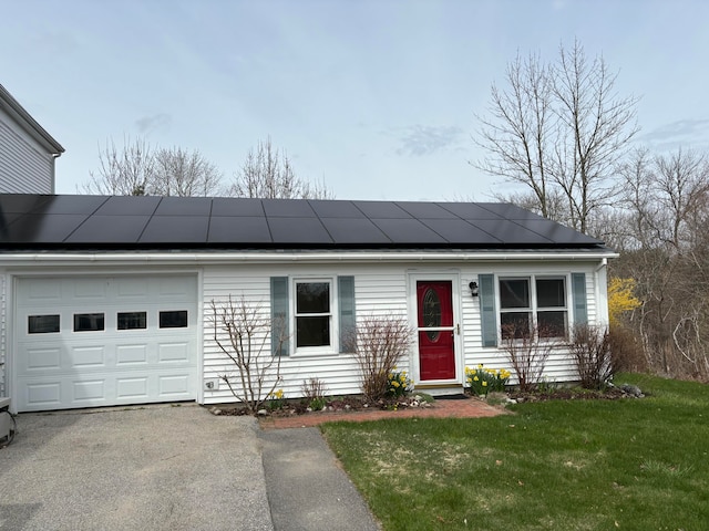 view of front of property featuring a front yard, solar panels, and a garage