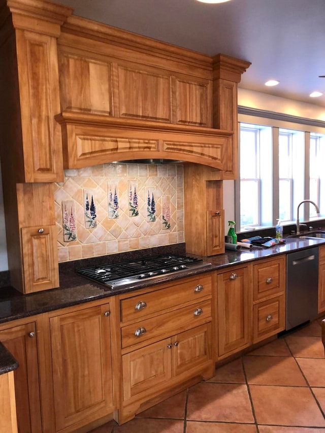 kitchen featuring light tile patterned floors, sink, tasteful backsplash, stainless steel appliances, and dark stone counters