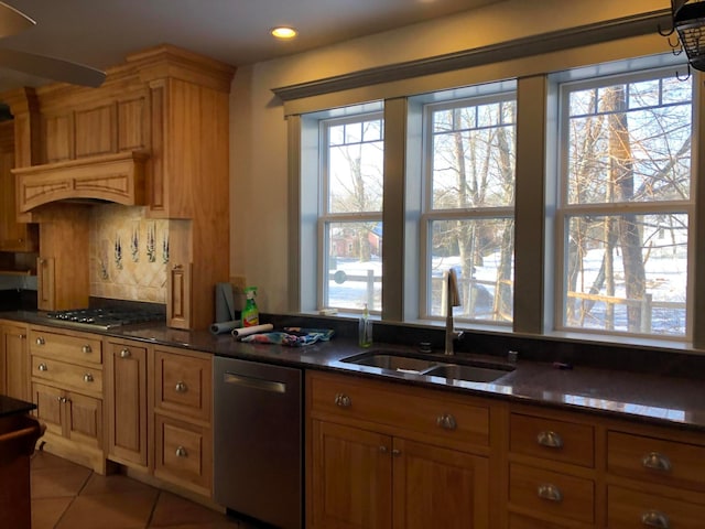 kitchen featuring decorative backsplash, light tile patterned floors, stainless steel appliances, dark stone counters, and sink