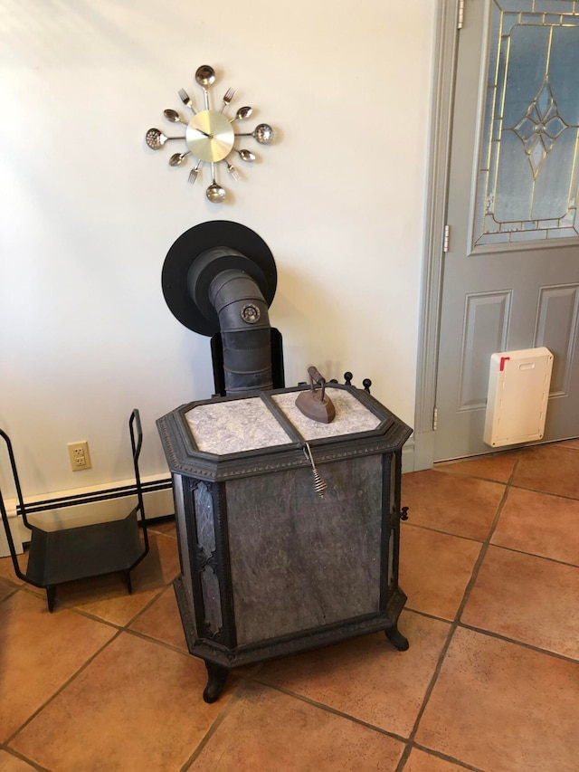 details with a baseboard heating unit, a wood stove, and tile patterned floors