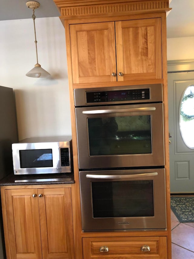 kitchen featuring decorative light fixtures, appliances with stainless steel finishes, and light tile patterned flooring