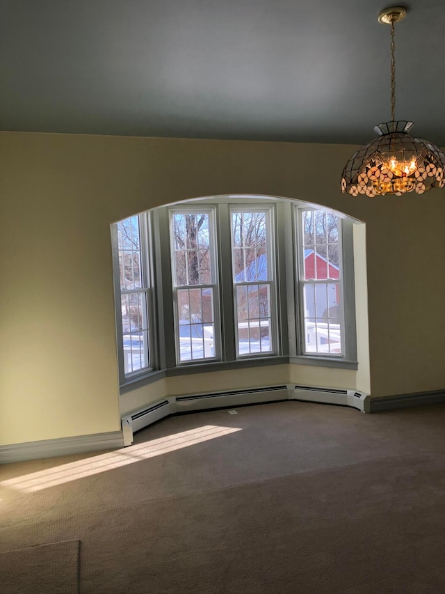 carpeted spare room with baseboard heating and a chandelier