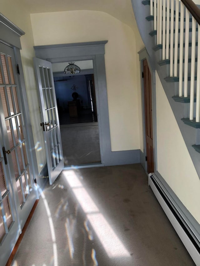 interior space with french doors, baseboard heating, and carpet flooring