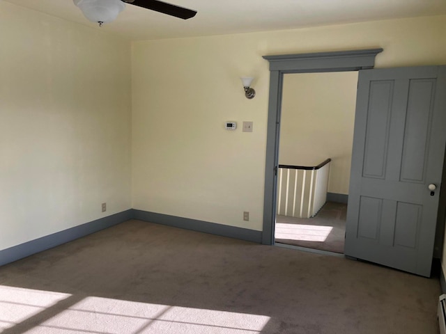 carpeted empty room featuring a baseboard radiator and ceiling fan