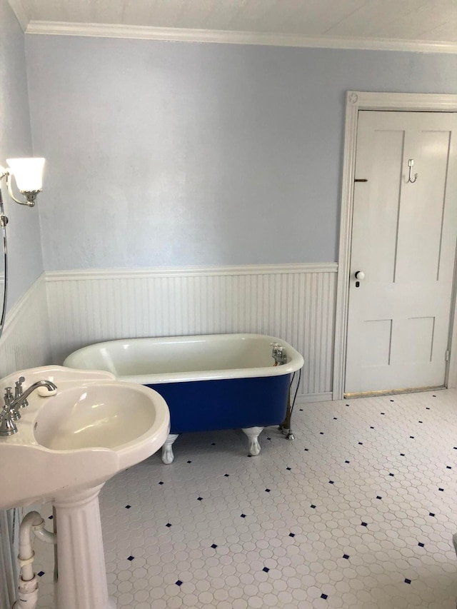 bathroom with a bath, tile patterned flooring, and ornamental molding