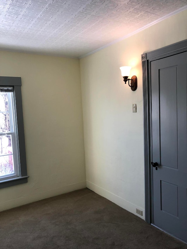 empty room featuring a textured ceiling and dark colored carpet