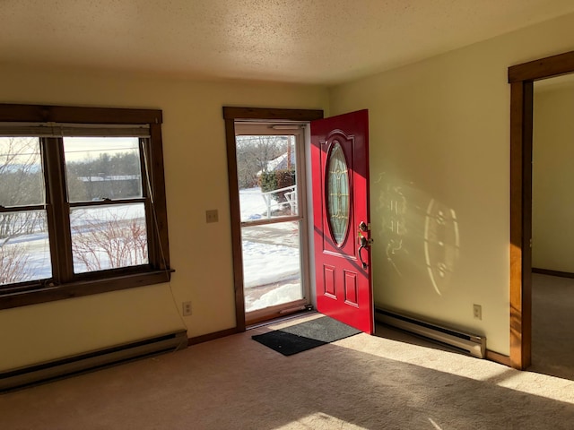 entryway with a textured ceiling, a baseboard heating unit, and carpet floors