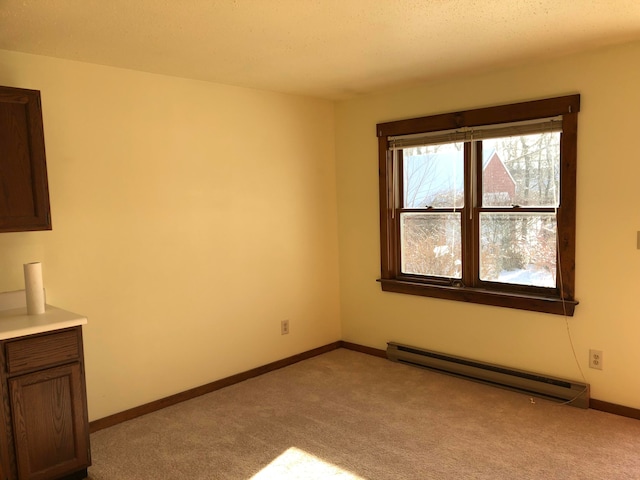 carpeted empty room with a baseboard heating unit