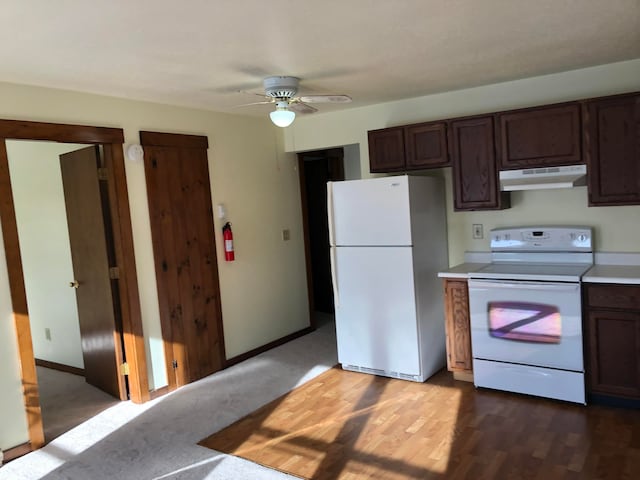 kitchen with dark brown cabinetry, white appliances, dark wood-type flooring, and ceiling fan