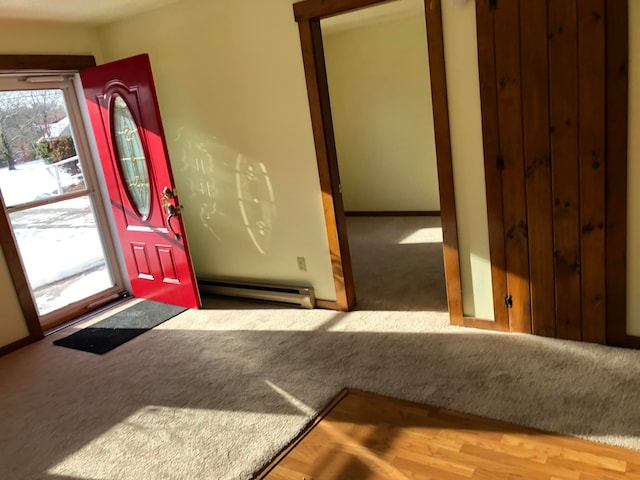 foyer entrance with hardwood / wood-style flooring and a baseboard heating unit