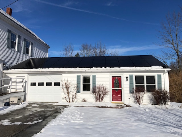 view of front of property with a garage and solar panels