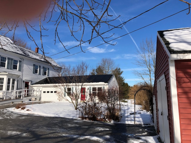 view of snowy exterior featuring a garage