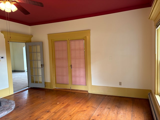 spare room with ornamental molding, ceiling fan, a baseboard heating unit, and light hardwood / wood-style flooring