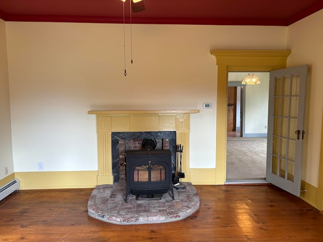 details featuring hardwood / wood-style flooring, baseboard heating, ornamental molding, and a wood stove