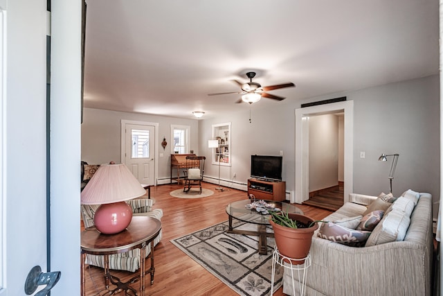 living room featuring ceiling fan, a baseboard heating unit, and light hardwood / wood-style flooring