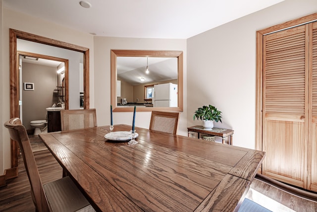 dining space featuring lofted ceiling and dark hardwood / wood-style flooring