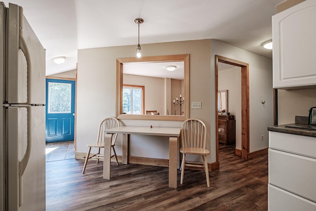 kitchen with pendant lighting, stainless steel refrigerator, dark hardwood / wood-style flooring, and white cabinetry