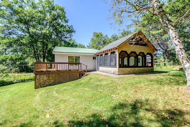 rear view of property with a deck and a yard