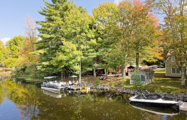 view of dock featuring a lawn and a water view