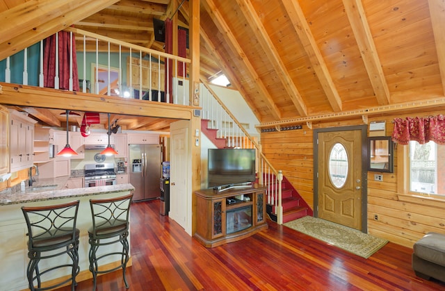 living room with sink, wooden walls, beam ceiling, and dark wood-type flooring