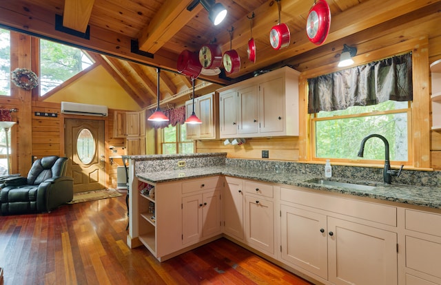 kitchen featuring a healthy amount of sunlight, vaulted ceiling with beams, decorative light fixtures, and wooden ceiling