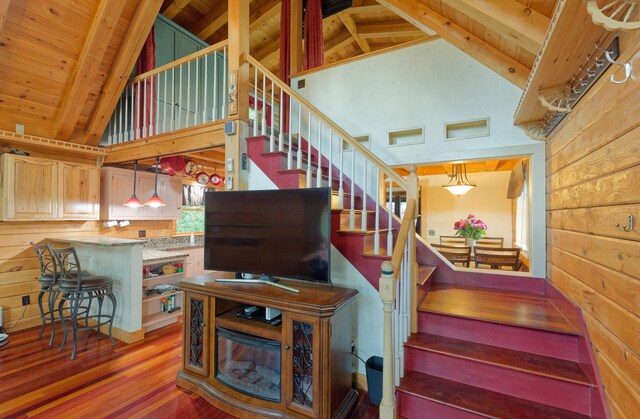 staircase with high vaulted ceiling, wood ceiling, wood-type flooring, and beamed ceiling