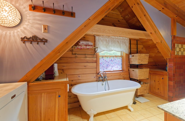 bathroom with vaulted ceiling with beams, vanity, a tub, and tile patterned floors