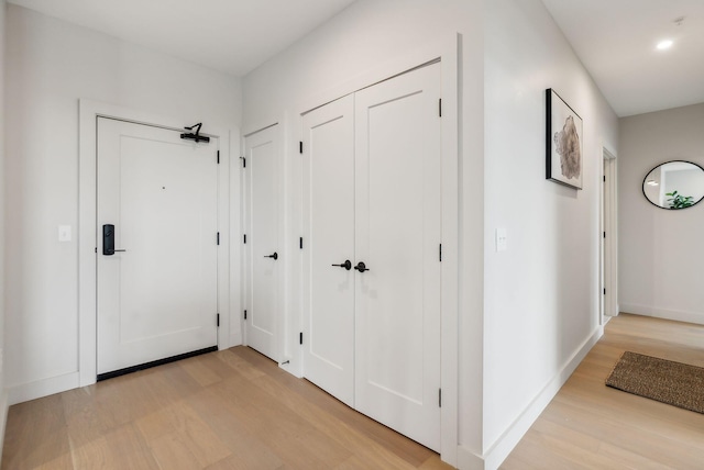 hallway with baseboards and light wood-style flooring