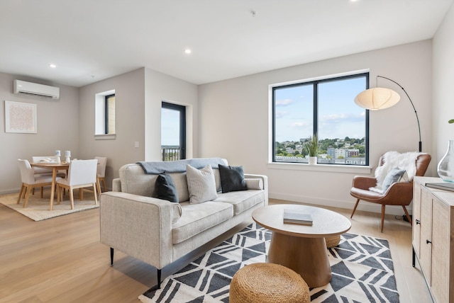 living area with an AC wall unit, baseboards, light wood finished floors, and recessed lighting