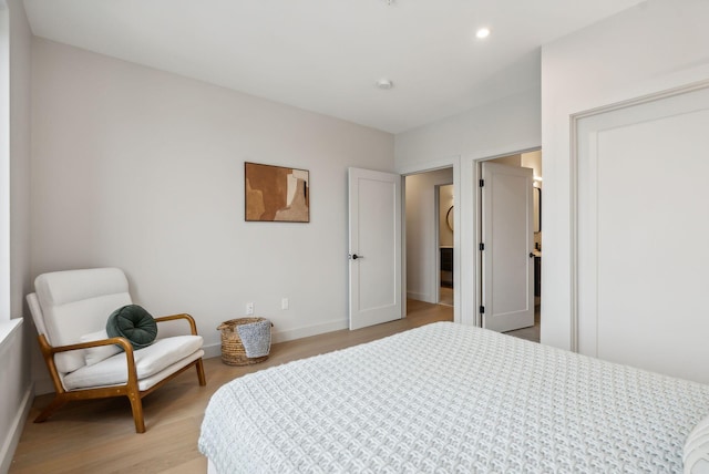 bedroom featuring baseboards, light wood-type flooring, and recessed lighting