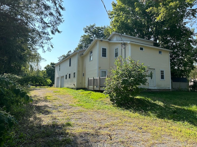 view of side of property with a yard and a garage